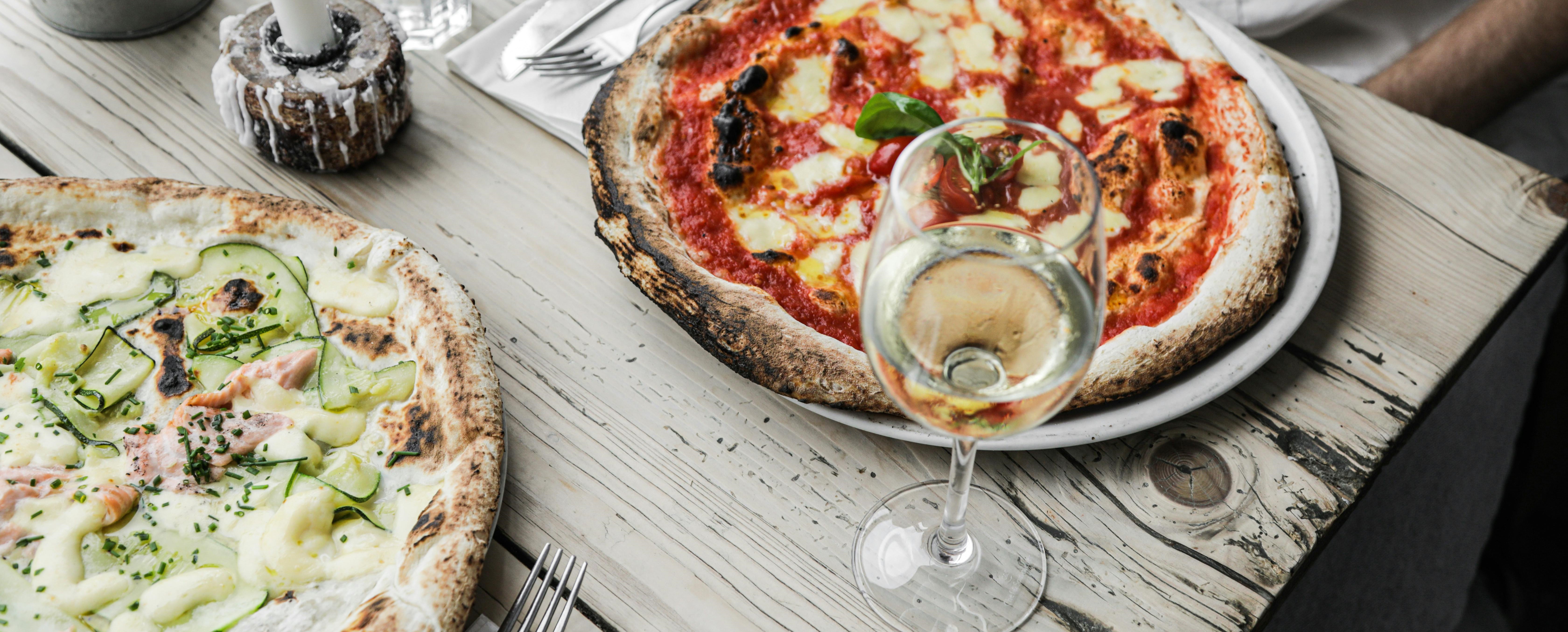 Gasten genieten van pizza op tafel